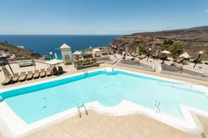 阿马多雷斯阿马多雷斯韦斯特公寓式酒店的一个大型的游泳池,背景是大海