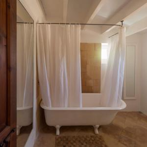 圣弗朗西斯科哈维尔Can Toni Platera的浴室内设有带浴帘的白色浴缸