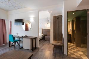 塞萨洛尼基大都市酒店的一间设有书桌的房间和一间带卧室的房间