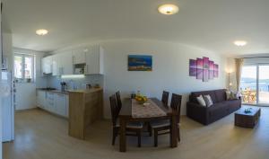 维斯Apartment Sandra (2+2) with a breathtaking view的厨房以及带桌子和沙发的客厅。