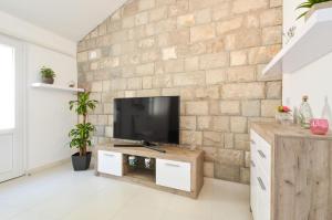 扎瓦拉提卡House Riva的一间客厅,在砖墙上配有电视