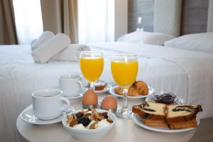 塞萨洛尼基大都市酒店的早餐盘包括鸡蛋、烤面包和两杯橙汁