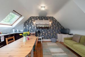 戈尔韦Luxury Apartment, bed and breakfast的厨房以及带木桌的起居室。