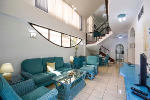 波多黎各Sunshine Beach Villas的客厅配有蓝色的沙发和桌子