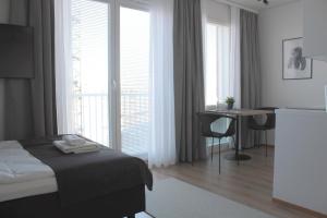 罗瓦涅米Forenom Serviced Apartments Rovaniemi Valtakatu的酒店客房设有一张床、一张书桌和窗户。
