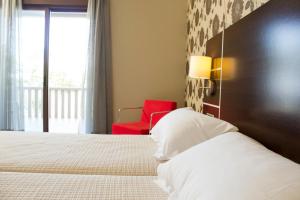 波多诺伏皮拉米德2酒店的一间卧室配有一张床和一张红色椅子