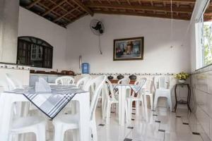 卡舒埃拉保利斯塔Casa & Hospedagem Carol的用餐室配有白色的桌子和白色的椅子