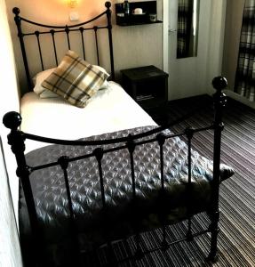 柯克沃尔West End Guest House的一张黑色的床,上面有枕头