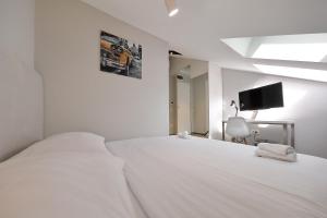 扎达尔市中心精品旅馆的白色卧室设有一张大白色床和电视