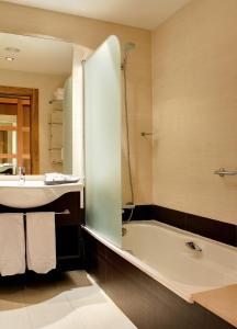 德瓦拉罗丽亚宫OCA酒店及Spa的带浴缸和盥洗盆的浴室