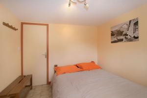 莱德萨阿尔卑斯Très bel appartement 4 pers Chalet Les Lupins - Les 2 Alpes的一间卧室配有一张带橙色枕头的床