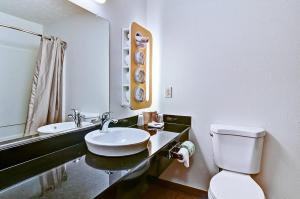MoonEconomy Inn的一间带水槽、卫生间和镜子的浴室