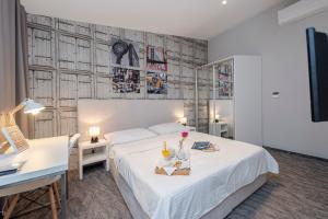 扎达尔市中心精品旅馆的卧室配有白色的床、书桌和书桌。