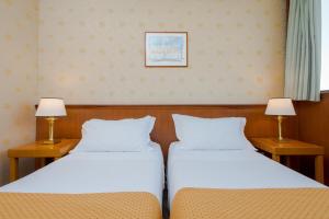 罗马Hotel The Brand的两张睡床彼此相邻,位于一个房间里