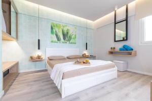 依克希亚Akalli Luxury Studios的卧室配有白色的床和蓝色的墙壁