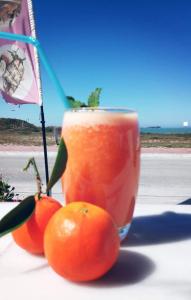 巴勒尔Gabana Baleal Beach的桌上的饮料和3个橙子