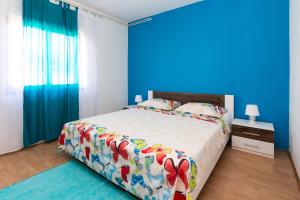 帕格Apartments Luka的一间卧室配有一张蓝色墙壁的床