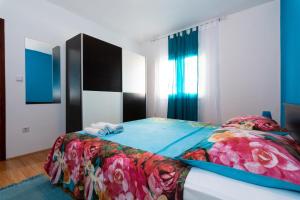 帕格Apartments Luka的一间卧室配有一张带花卉棉被的床