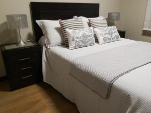 布埃乌Apartamento AGRELO的一间卧室配有带白色床单和枕头的床。
