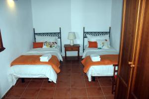 LoderoMama Yé的铺有瓷砖地板的客房内设有两张单人床。