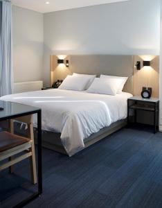 拉巴斯Casa Grande Express的卧室配有一张带白色床单和枕头的大床。