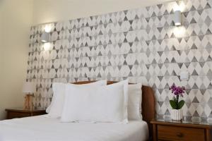 波尔图Hotel Visconde的卧室配有白色床和 ⁇ 形墙