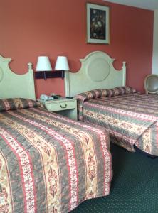 新奥尔良新奥尔良酒店的红色墙壁的酒店客房内的两张床