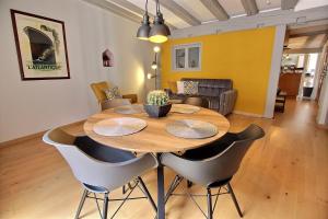 科尔马LE PTIT BARTHO的一间带木桌和椅子的用餐室