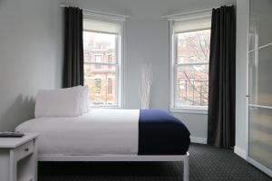 波士顿Stylish Newbury Street Studio, #4的一间卧室设有一张床和两个窗户。