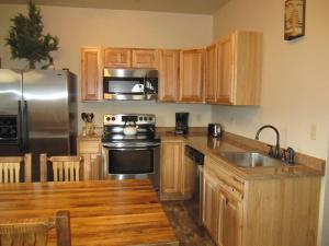 麋鹿城Mountain Man Cabin的厨房配有木制橱柜和不锈钢冰箱。