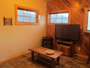 麋鹿城Mountain Man Cabin的一间带电视和木墙的客厅