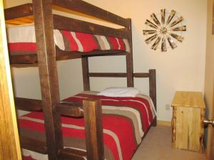 麋鹿城Mountain Man Cabin的一间卧室设有两张双层床和时钟