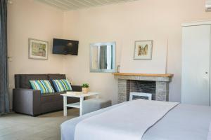 费斯卡尔德宏Martini Waterfront Suites的一间卧室配有一张床、一张沙发和一个壁炉