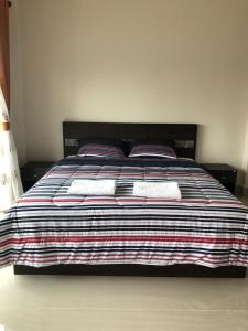 PrakhamPakham Gardens Resort的一张带两个枕头和条纹毯子的床