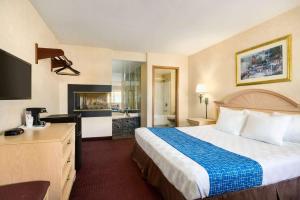 尼亚加拉瀑布尼亚加拉瀑布城温德姆旅程住宿 - 纽约的酒店客房设有一张大床和一个壁炉。