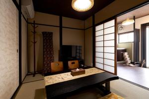 京都憩 出町柳２(ikoi DemachiyanagiⅡ)的一间设有白色墙壁的客房和一间带桌子的房间
