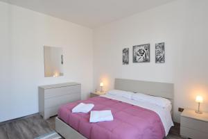 贝拉吉奥粉红之家公寓酒店的一间卧室配有一张带2晚台的大型粉红色床