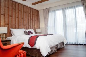 小琉球岛泰美风情旅店的一间卧室配有一张大床和一张红色椅子