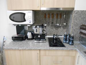 波罗维茨Студио D-41 в Апарт-хотел Боровец Гардънс的厨房柜台配有咖啡机和微波炉