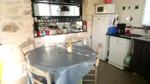 BaronGîtelabaronnaise avec piscine chauffée prés parc Asterix的厨房配有带瓶子的桌子