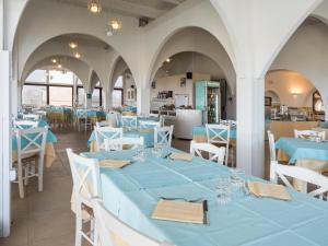 斯廷蒂诺卡拉雷阿乐酒店的用餐室配有蓝色桌子和白色椅子