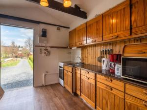 Gouvy乐福盖2号小木屋的一个带木制橱柜和大窗户的厨房