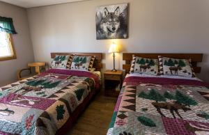 莱昂斯黑德Bear Tracks Inn的一间卧室设有两张带圣诞棉被的床