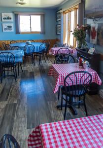 莱昂斯黑德Bear Tracks Inn的餐厅配有红色和白色的桌椅