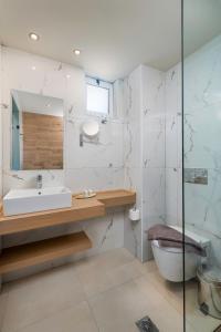 蒂加基艳阳天酒店的一间带水槽、卫生间和镜子的浴室