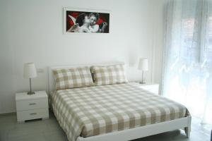 里米尼Residence Fanny的一间卧室配有一张带 ⁇ 子毯子和照片的床