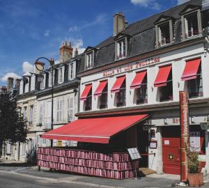 拉沙里泰Hôtel Mille et une Feuilles的街上有红色遮阳篷的建筑
