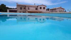 佩雷拉达La Masia de Montpedrós的别墅前设有游泳池