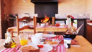 佩雷拉达La Masia de Montpedrós的餐桌,餐桌上放着一盘食物,壁炉