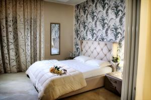 庞贝B&B Pompei Olympus的一间卧室配有一张白色大床,床上有鲜花